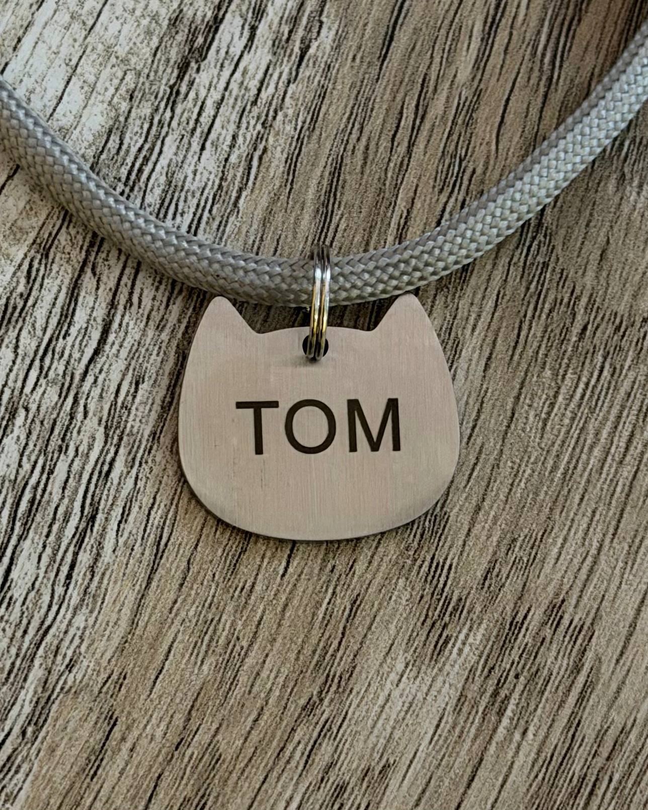 Cat face pet tag with Tom engraving